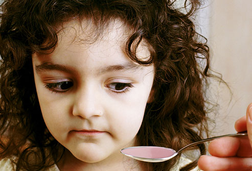 getty rm photo of girl eyeing spoonful of medicine